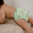 Load image into Gallery viewer, Baby wearing a Reusable Cloth Nappy – Cockatoo | 2.0 | My Little Gumnut shown to demonstrate fit and comfort.
