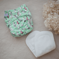 Load image into Gallery viewer, Baby wearing a Reusable Cloth Nappy – Cockatoo | 2.0 | My Little Gumnut shown to demonstrate fit and comfort.
