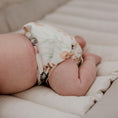 Load image into Gallery viewer, A baby wearing a reusable newborn cloth nappy in a floral design, showcasing comfort and style for eco-conscious parents.