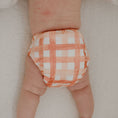 Load image into Gallery viewer, Reusable Newborn Cloth Nappy in Gingham (Rust) design on a baby's bottom.