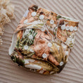 Load image into Gallery viewer, Reusable Newborn Cloth Nappy with a Dino Land dinosaur pattern featuring buttons and colorful design.
