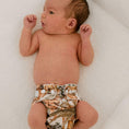 Load image into Gallery viewer, Reusable Newborn Cloth Nappy on a baby, featuring a floral design, showcasing comfort and style for newborns.