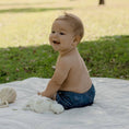 Load image into Gallery viewer, Baby wearing a Reusable Cloth Nappy – Monstera Blue | 2.0 | My Little Gumnut shown sitting outdoors to demonstrate comfort and flexibility.