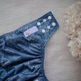 Load image into Gallery viewer, Reusable Cloth Nappy – Monstera Blue | 2.0 | My Little Gumnut folded flat to showcase the blue botanical print and adjustable fit.