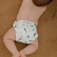 Load image into Gallery viewer, Reusable Swim Nappy on a baby playing on the sand, designed for comfort and reducing waste.