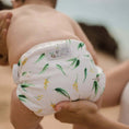 Load image into Gallery viewer, Reusable Swim Nappy - Gumnut held by a caregiver, designed for beach days and pool play.