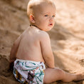 Load image into Gallery viewer, Baby wearing a Banksia reusable swim nappy by My Little Gumnut, enjoying the sandy beach.
