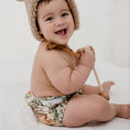 Load image into Gallery viewer, Baby wearing a Reusable Cloth Nappy – Dino Land | 2.0 | My Little Gumnut with a secure fit and soft bamboo lining.