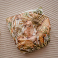 Load image into Gallery viewer, Reusable Cloth Nappy – Dino Land | 2.0 | My Little Gumnut folded flat to highlight the playful dinosaur print detail.
