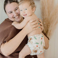 Load image into Gallery viewer, Baby wearing a Reusable Cloth Nappy – Bees | 2.0 | My Little Gumnut with a secure fit and soft bamboo lining.