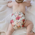 Load image into Gallery viewer, Baby wearing a Reusable Cloth Nappy – Blush Botanical | 2.0 | My Little Gumnut with a secure fit and soft bamboo lining.