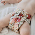 Load image into Gallery viewer, Baby wearing a Reusable Cloth Nappy – Blush Botanical | 2.0 | My Little Gumnut shown to demonstrate fit and comfort.