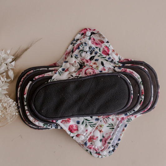 Reusable menstrual pads by my little gumnut. cloth menstrual pads. period pads. stack of menstrual pads. floral pads