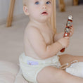 Load image into Gallery viewer, Baby wearing a Reusable Cloth Nappy – Ivory | 2.0 | My Little Gumnut with a secure fit and soft bamboo lining.