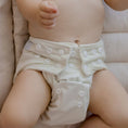 Load image into Gallery viewer, Baby wearing a Reusable Cloth Nappy – Ivory | 2.0 | My Little Gumnut shown to demonstrate fit, comfort and soft bamboo lining.