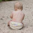 Load image into Gallery viewer, Baby sitting on sandy ground wearing a Reusable Swim Nappy in Gingham (Beige) from My Little Gumnut.