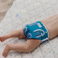 Load image into Gallery viewer, Reusable Swim Nappy - Rainbow (Blue) on a baby, designed for comfort during swim activities.