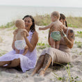 Load image into Gallery viewer, Two mothers enjoying a beach day with babies wearing Reusable Swim Nappy - Sage, showcasing comfort and style.