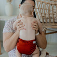 Load image into Gallery viewer, Baby wearing a Reusable Cloth Nappy – Terracotta | 2.0 | My Little Gumnut shown from behind to demonstrate fit and comfort.