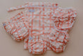 Load image into Gallery viewer, Gingham (Rust) reusable wet bag displayed with cloth nappy essentials and accessories 💚