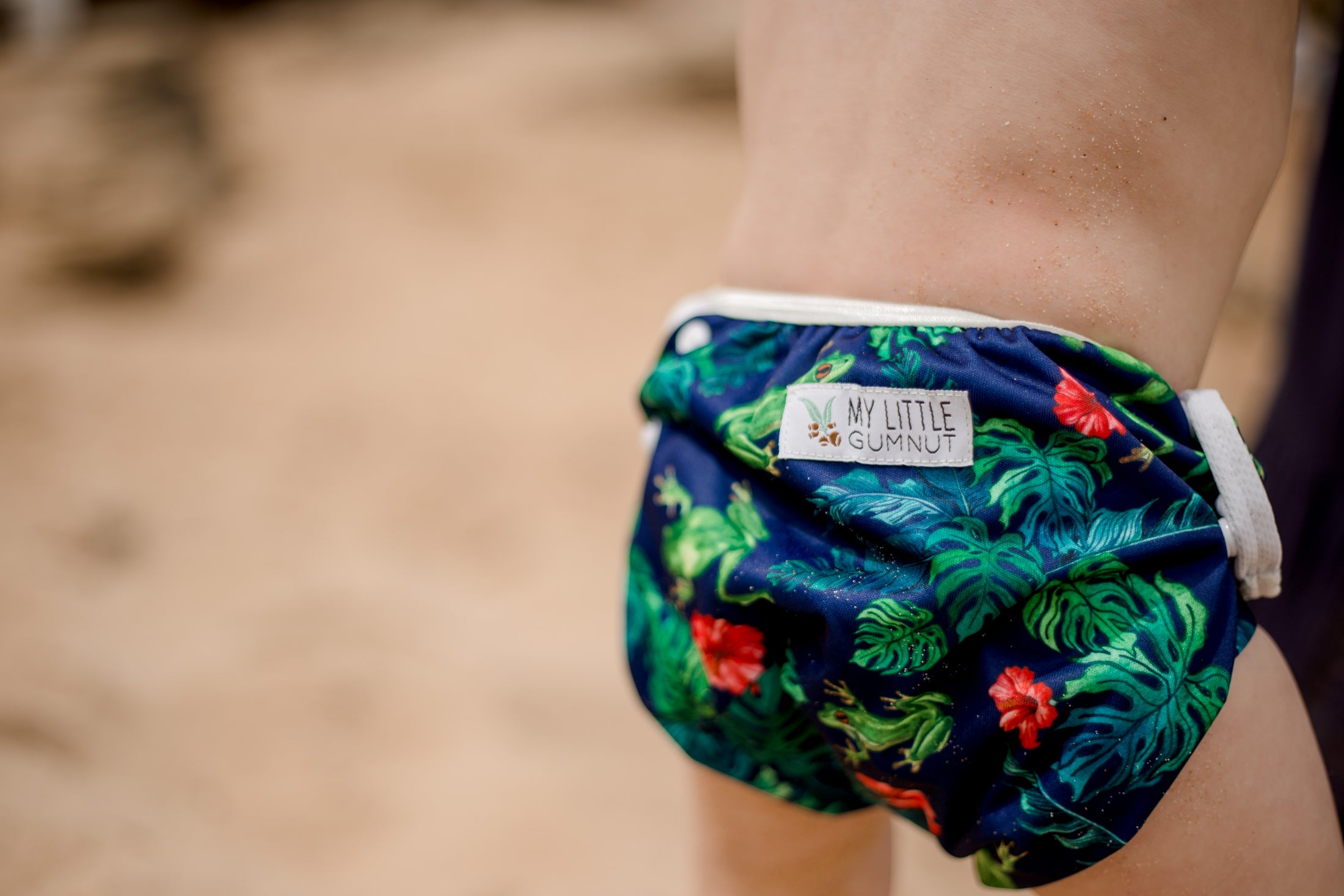 Beach baby wearing Tropical frog swimming nappy. Australian artist desgined swimming nappy. My little gumnut.