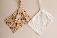 Load image into Gallery viewer, Retro Flowers reusable wet bag displayed with reusable wipes and baby essentials
