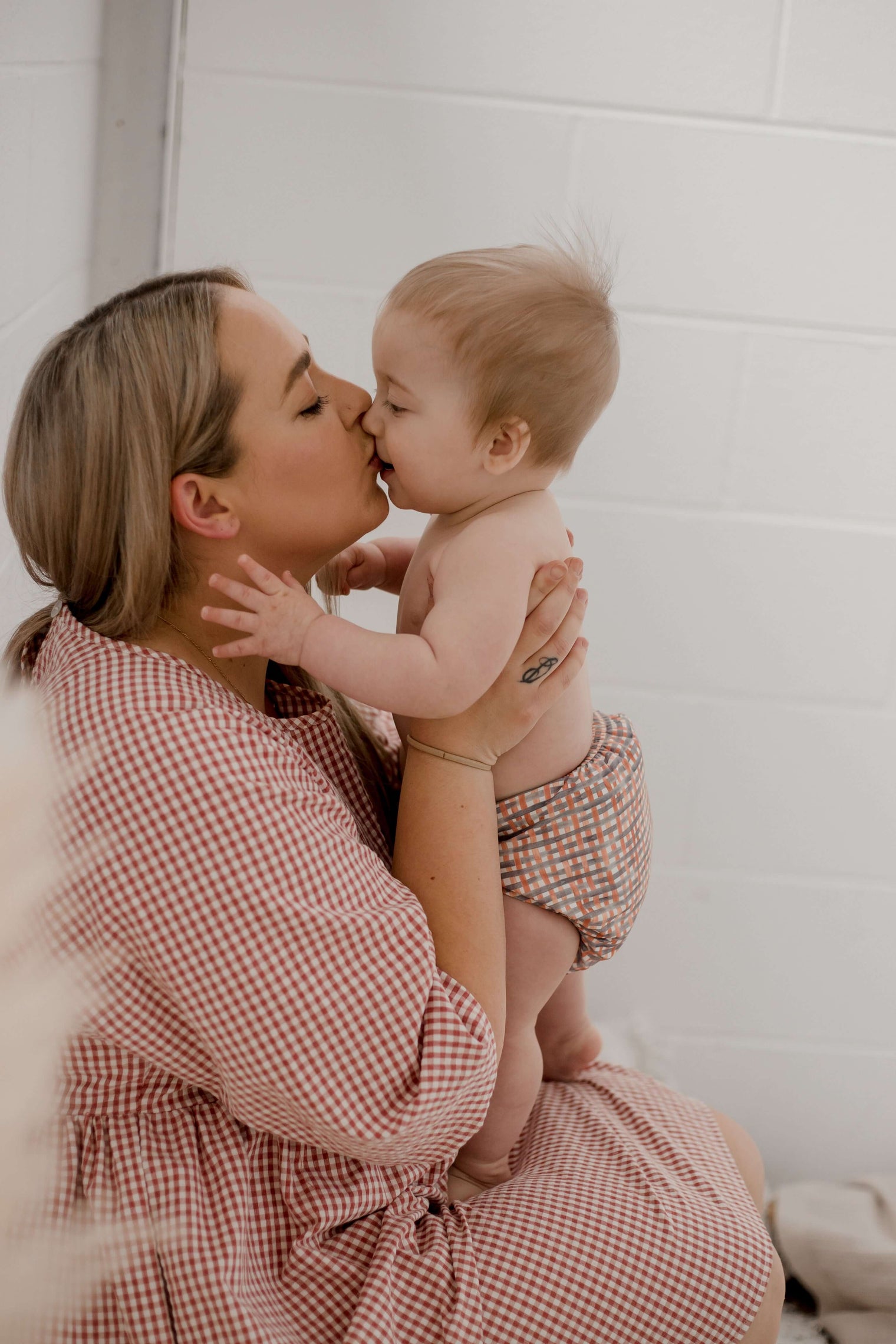 Mum kissing baby wearing Plaid design My Little Gumnut Cloth Nappy