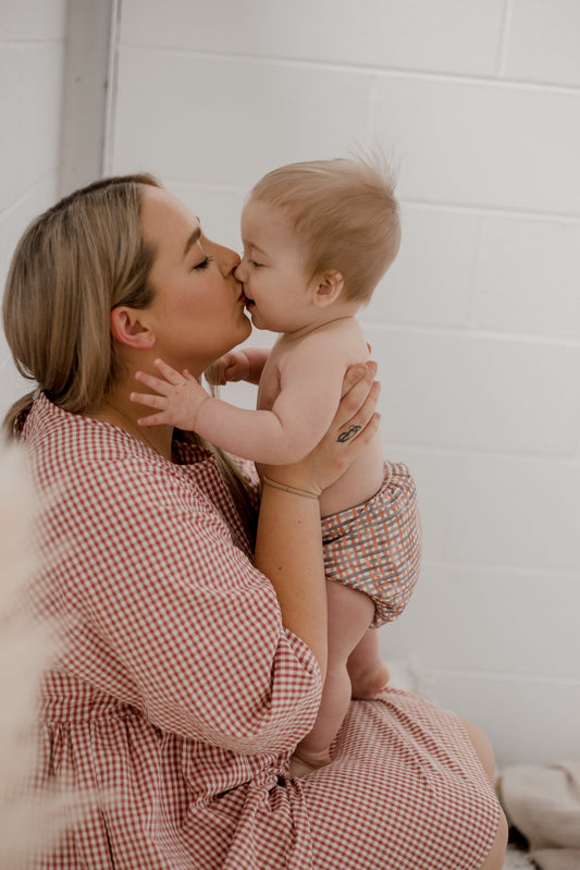 Mum kissing baby wearing Plaid design My Little Gumnut Cloth Nappy