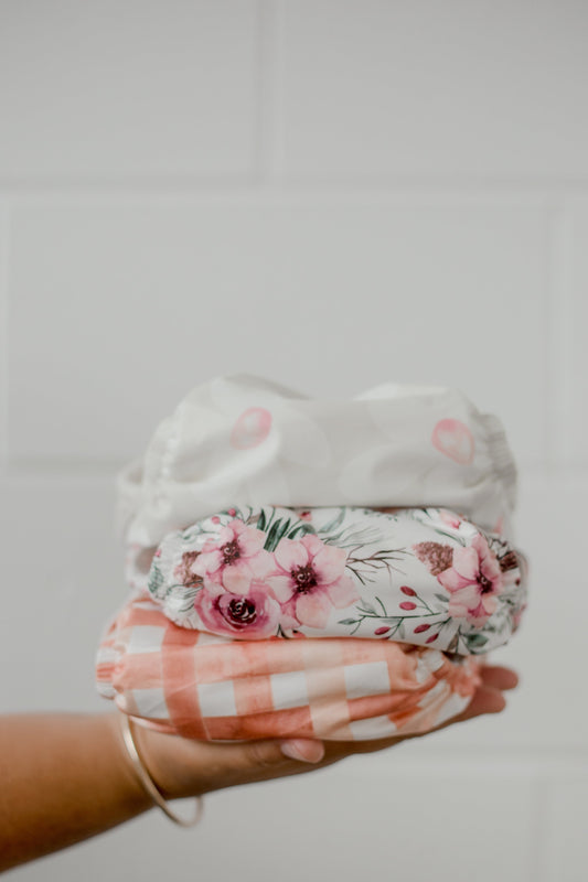 A hand holding three My Little Gumnut Cloth Nappies