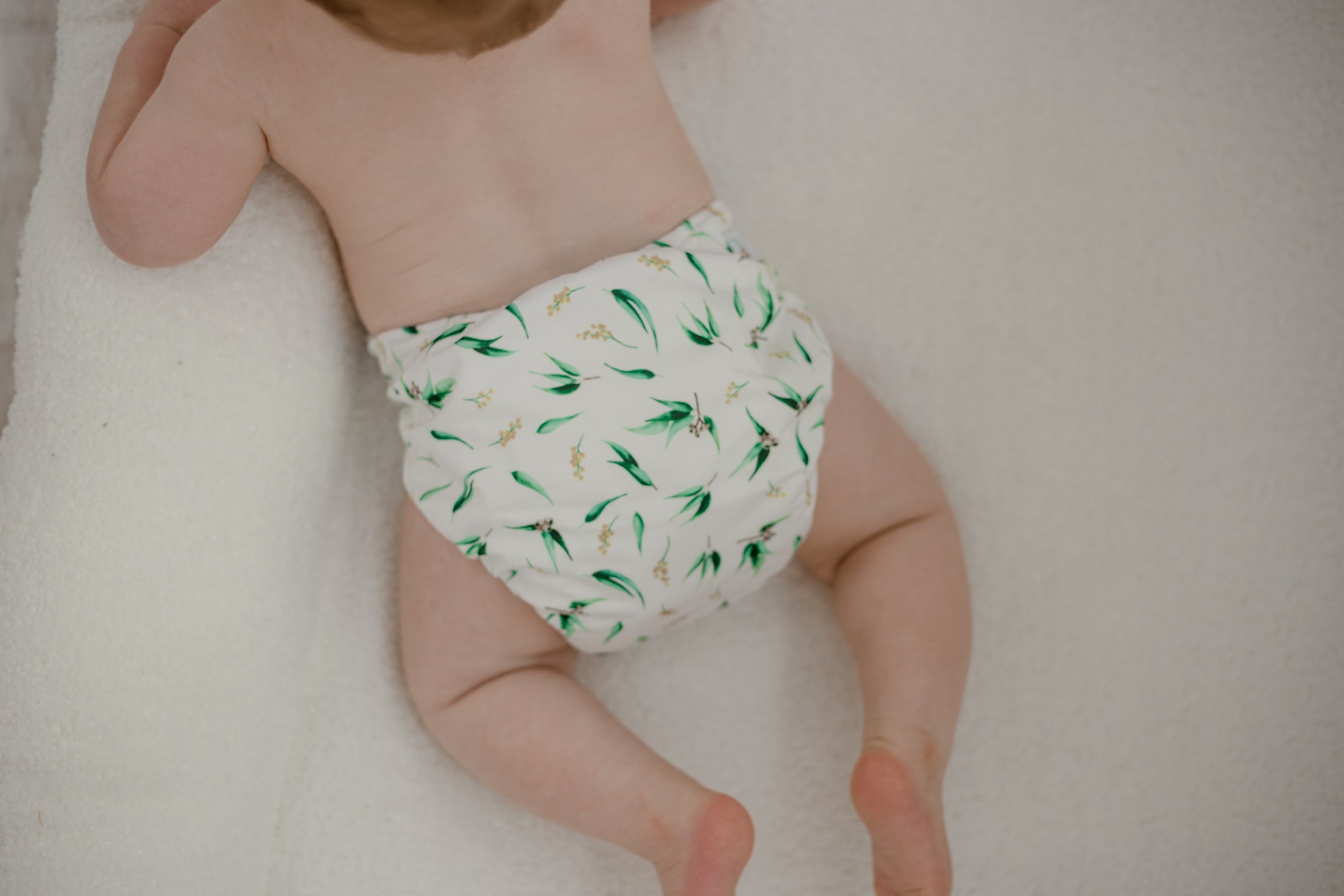 Baby wearing Gumnut print Cloth Nappy by My Little Gumnut. Australian inspired reusabe nappies. Native australian flora and fauna. Eco nappies.