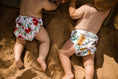 Load image into Gallery viewer, Beach baby in Flowering gum and banksia Australiana swim nappy. Reusable swimming nappy. My little gumnut. 
