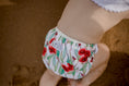 Load image into Gallery viewer, beach baby wearing Flowering gum Australiana swim nappy. Reusable swimming nappy. My little gumnut. 
