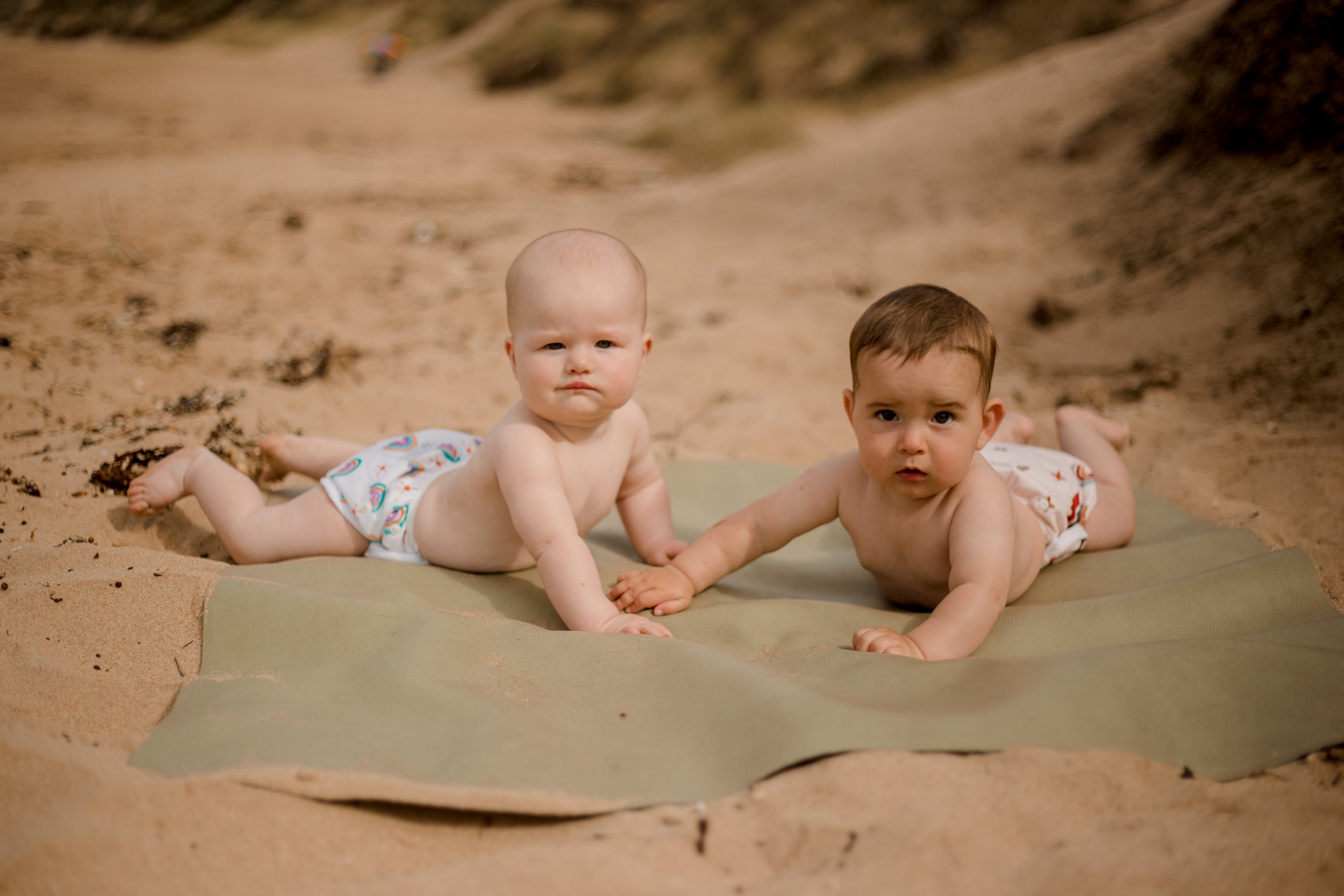 beach baby wearing  pastel rainbow swimming nappy. Australian artist designed swim nappy. My little Gumnut. 