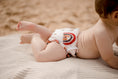 Load image into Gallery viewer, Beach baby wearing Rainbow earth tones swimming nappy. Australian artists designed swim nappy. My little gumnut. 
