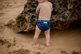 Load image into Gallery viewer, Beach baby wearing Boho navy swimming nappy. Australian designed swim nappies. My Little Gumnut.
