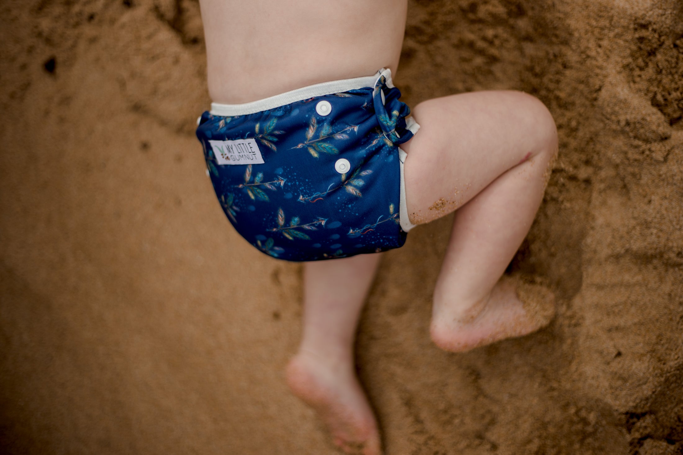 Beach baby wearing Boho navy swimming nappy. Australian designed swim nappies. My Little Gumnut.