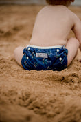 Load image into Gallery viewer, Beach baby wearing Boho navy swimming nappy. Australian designed swim nappies. My Little Gumnut.
